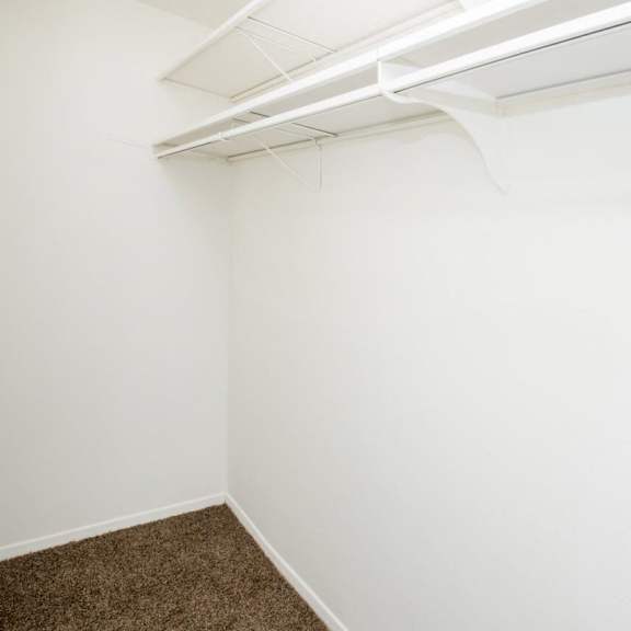 an empty room with a white wall and a white closet