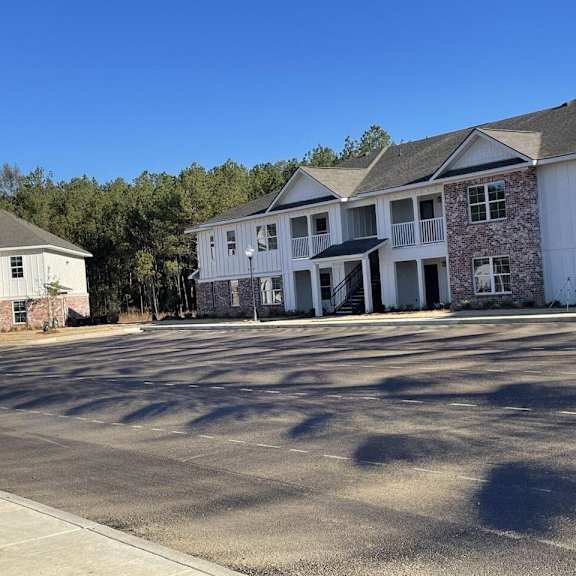 an empty parking lot in front of two apartment buildings
