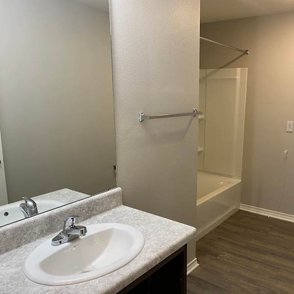 a bathroom with a toilet, sink, and mirror.