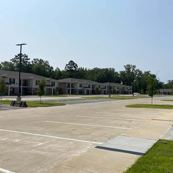 a parking lot with a few cars and a building in the background.