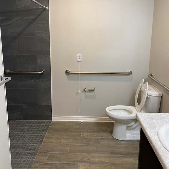 a white toilet sits in a bathroom next to a shower.