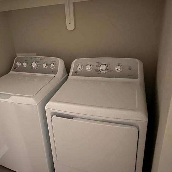 two white front loading washing machines in a small laundry room.