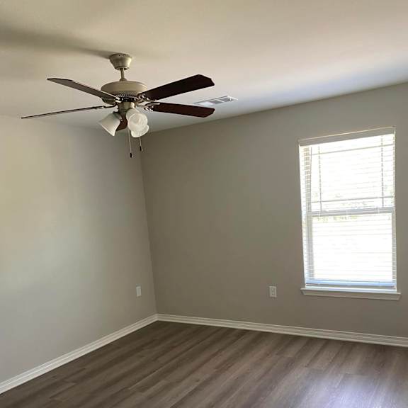 a room with a ceiling fan and a window.