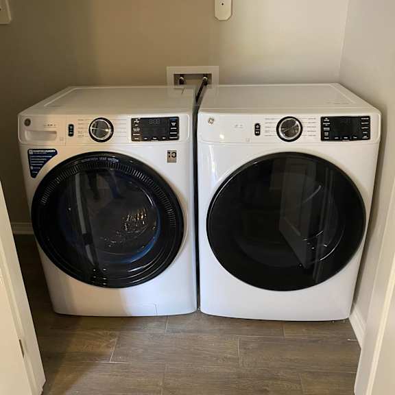 two front loading washing machines in a laundry room.