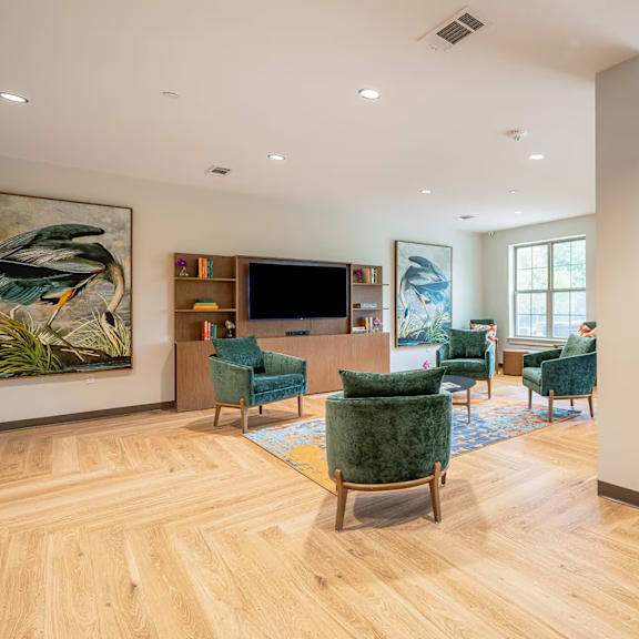a living room with a wooden floor and a large painting on the wall.