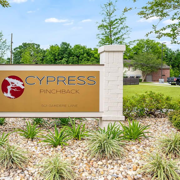 a sign for cypress pinchback stands in a landscaped area.