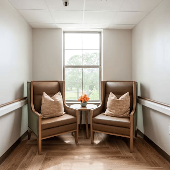 two chairs are placed in a room with a window.
