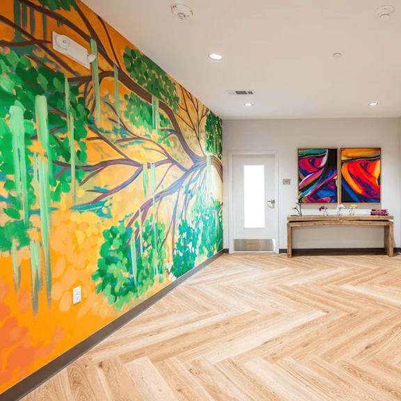 a hallway with a mural of a tree on the wall.