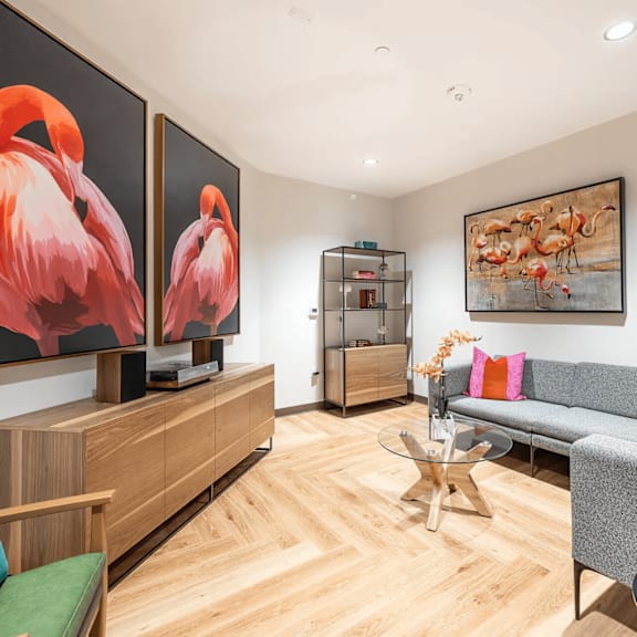 a living room with a couch, a coffee table, and two large paintings on the wall.