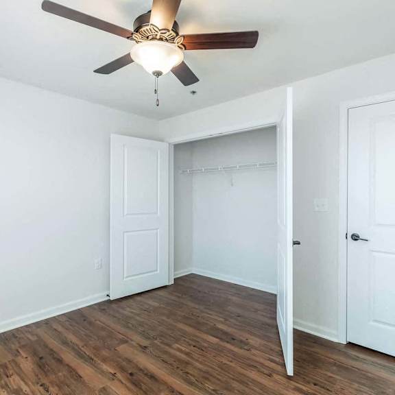 a bedroom with a ceiling fan and a closet