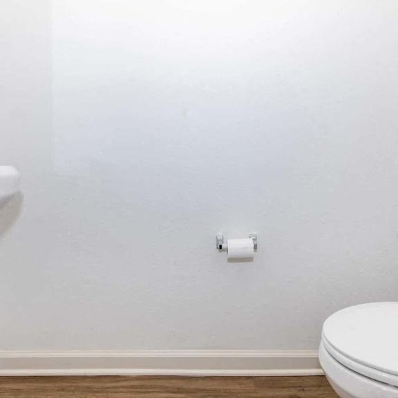 a bathroom with a toilet and some lights on the wall