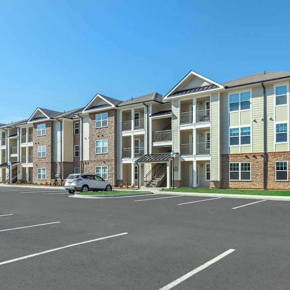 an empty parking lot in front of an apartment building