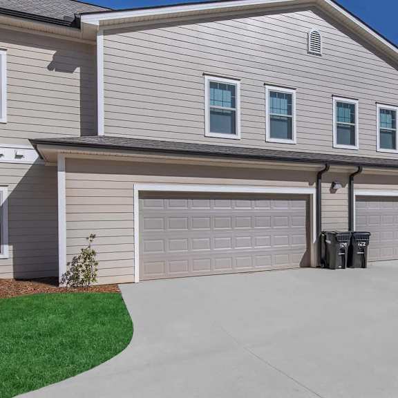 a white house with a garage door and a driveway