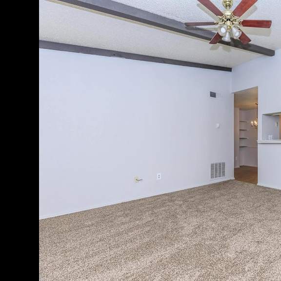a room with a ceiling fan and a door on the right side.