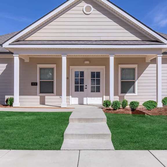a white house with a sidewalk in front of it