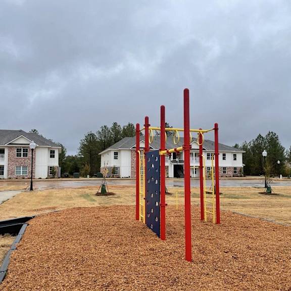 a playground in a park with houses in the background