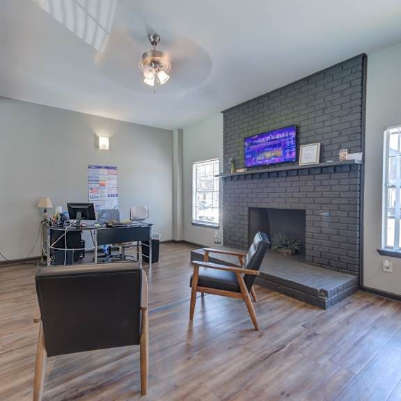 a living room with a fireplace and a tv mounted above it.
