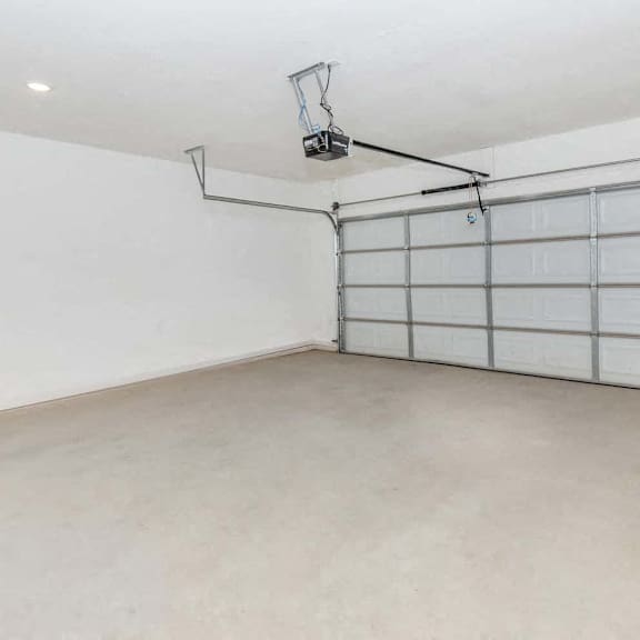 an empty garage with a white wall and a garage door