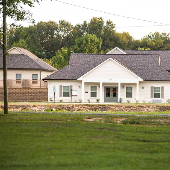 a white house with a yard in front of it