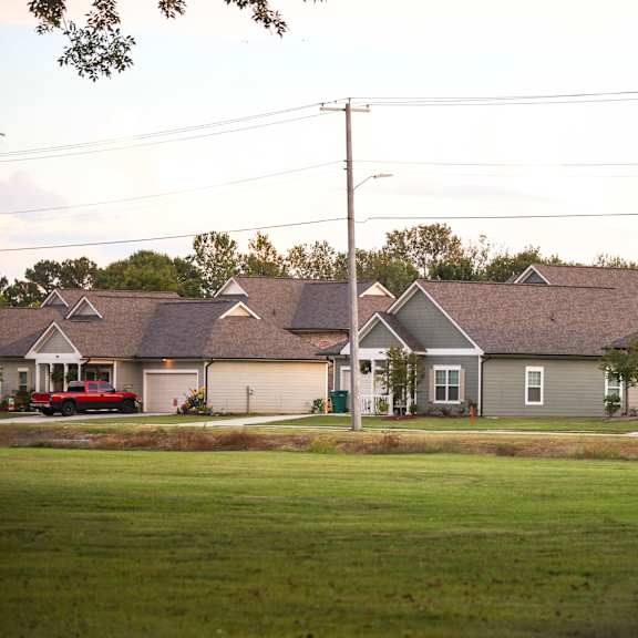 a row of houses on a street in front of a field