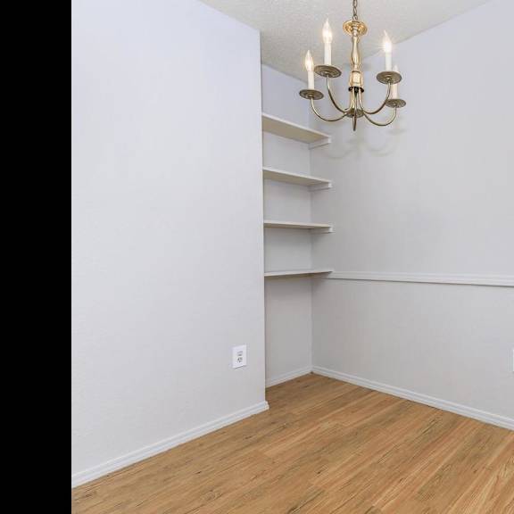 a room with a wooden floor and a chandelier.