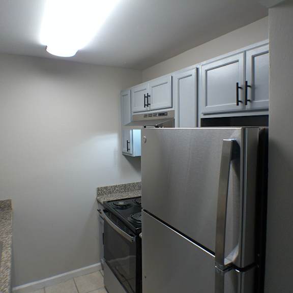 a kitchen with stainless steel appliances and white cabinets