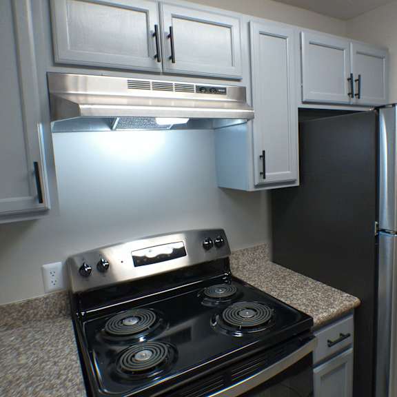 a kitchen with white cabinets and a stove and refrigerator