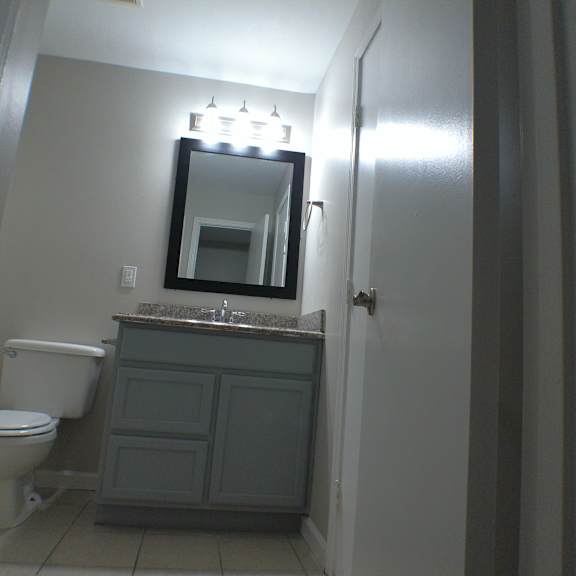 a bathroom with a toilet and a sink and a mirror