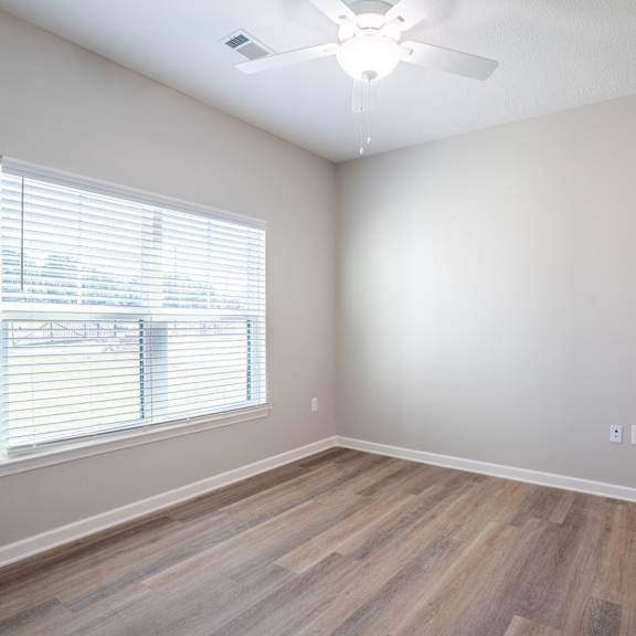 a room with a window and wooden flooring.