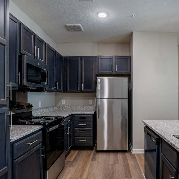 a kitchen with dark wood cabinets and stainless steel appliances.