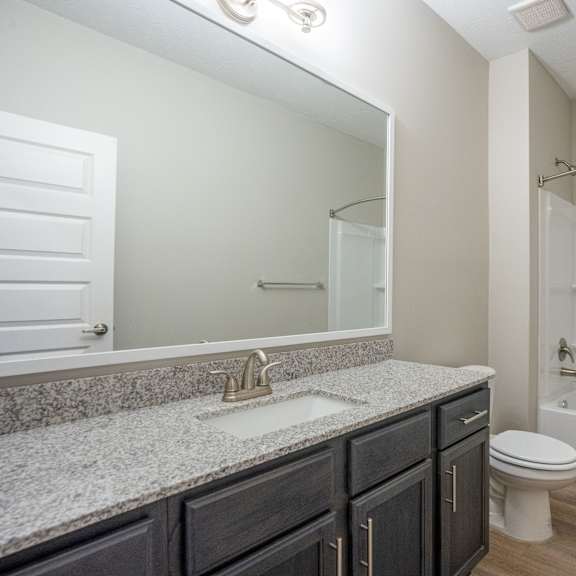 a bathroom with a white tub, sink, and toilet.