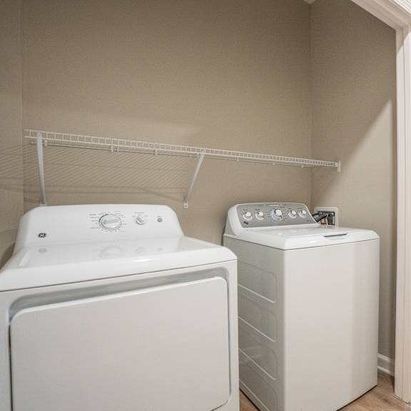 a white dryer and washer are in a laundry room.