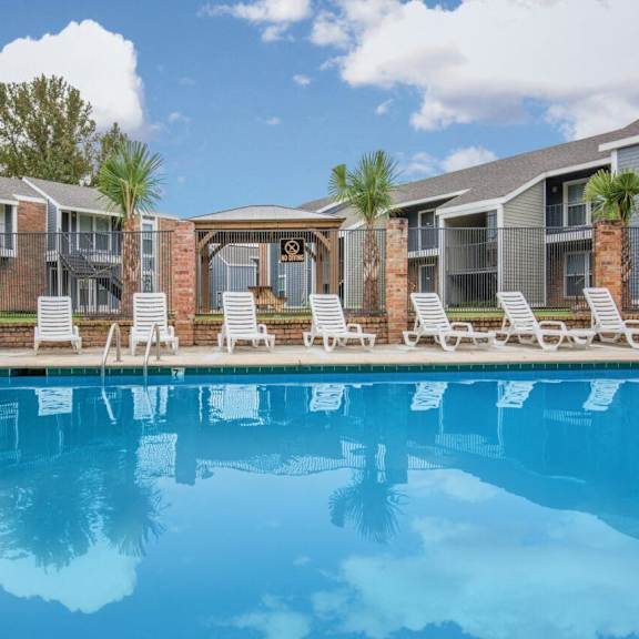 a swimming pool in front of a row of apartment buildings