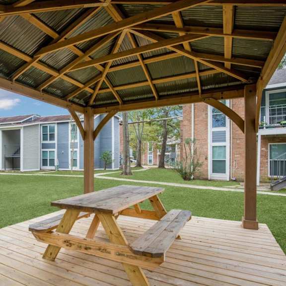 a picnic table on a deck in front of a building