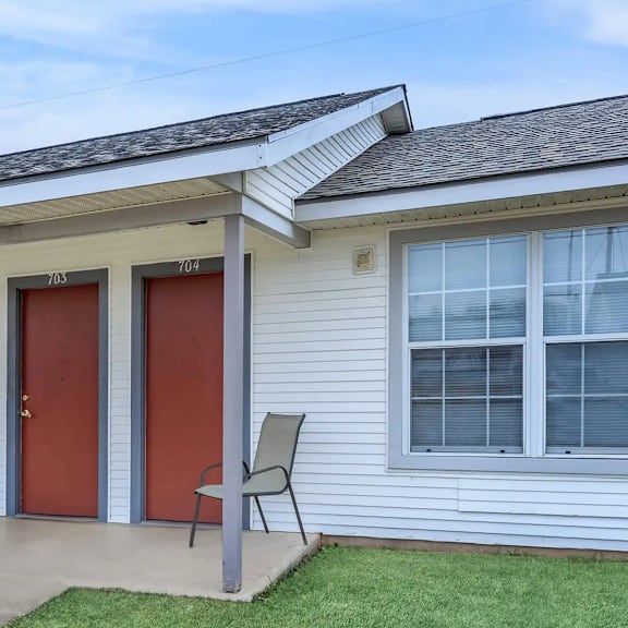 a house with a red door and a grey chair.