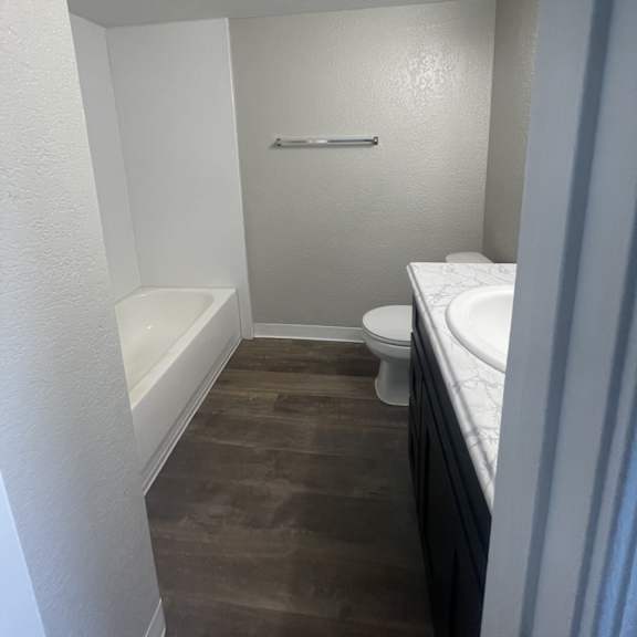 a small bathroom with a toilet, sink, and bathtub.