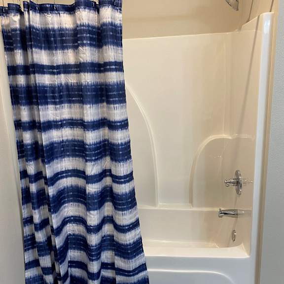 a bathroom with a shower curtain and a bath tub