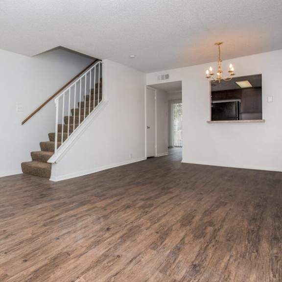 an empty living room with white walls and a staircase