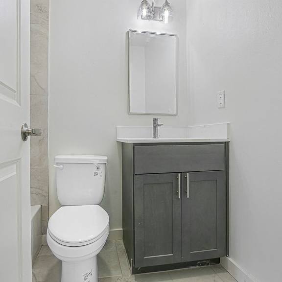 a white toilet sits next to a sink in a bathroom.