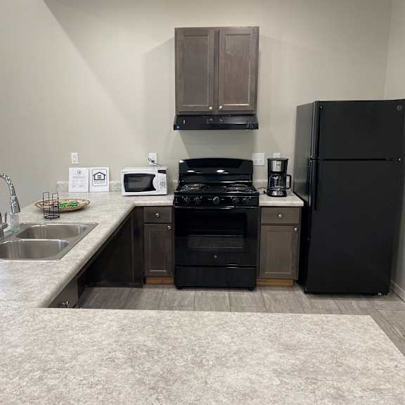 a kitchen with black appliances and a sink and a refrigerator