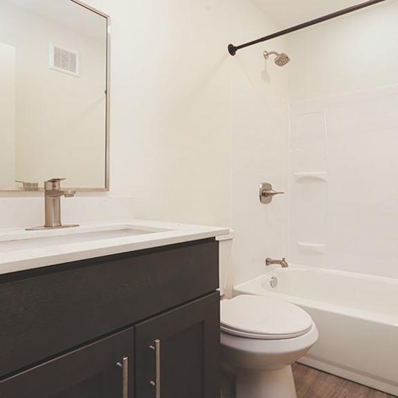 a white toilet sits next to a white bathtub in a bathroom.