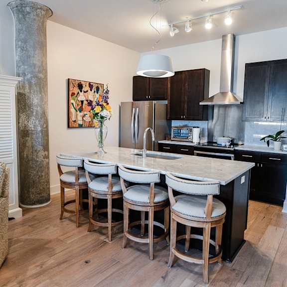 a kitchen with a white sofa and a wooden table.