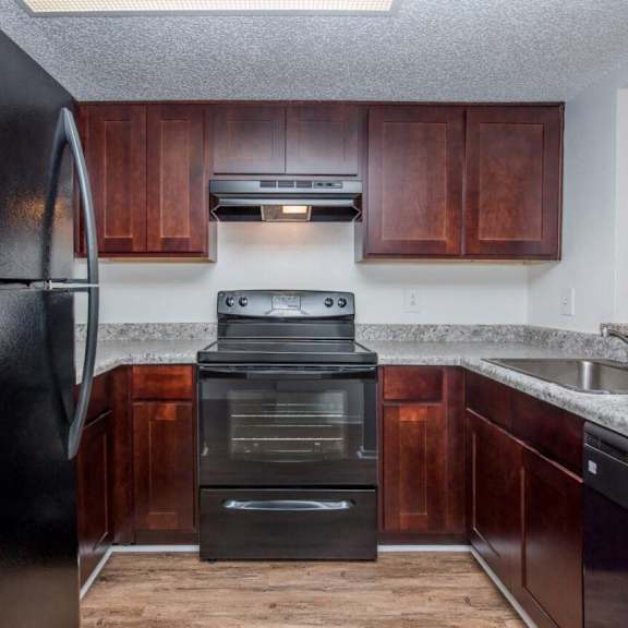 a close up of a kitchen with wood cabinets