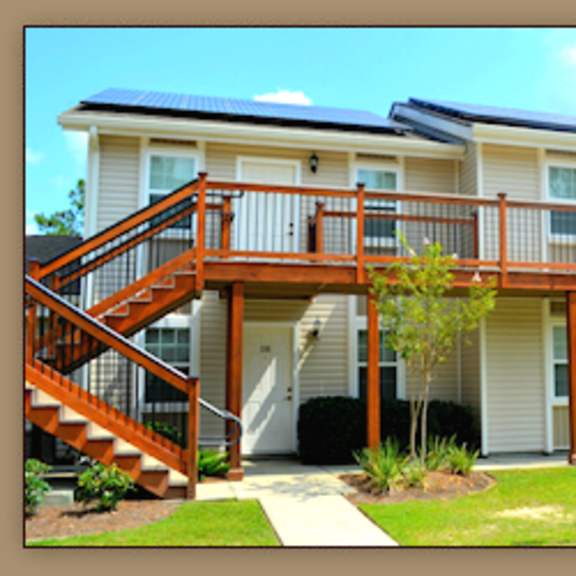a house with a staircase leading to a deck.