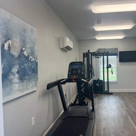 a gym with treadmills and exercise equipment.