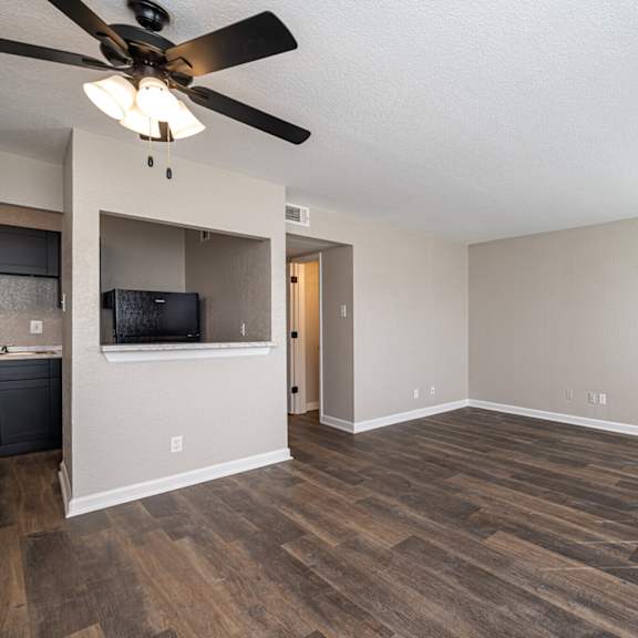 a room with a ceiling fan and a flat screen tv mounted on the wall.