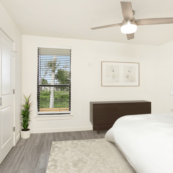 a bedroom with a bed, a ceiling fan, and a window with blinds.