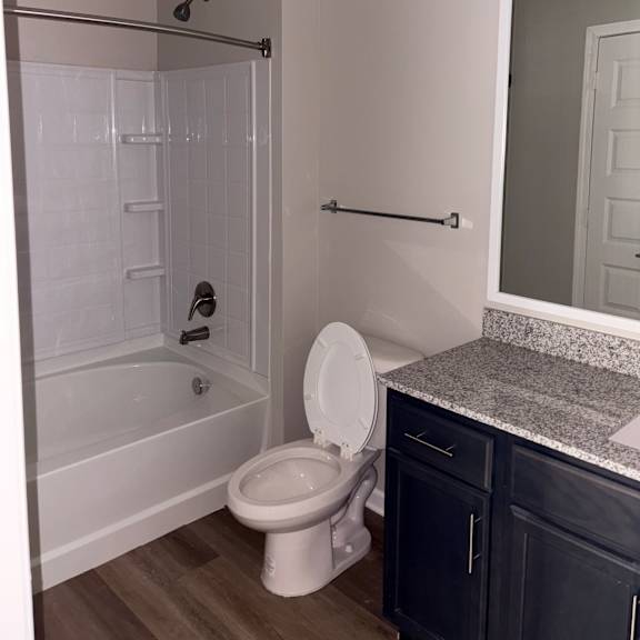 a bathroom with a toilet, a shower, and a sink.
