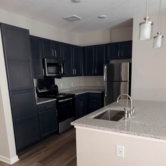 a modern kitchen with a stainless steel oven and black countertops.
