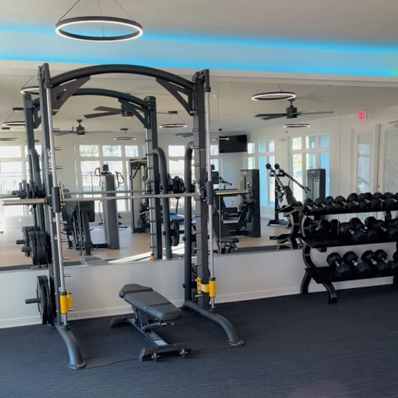 a gym with a variety of equipment including weights and a bench.